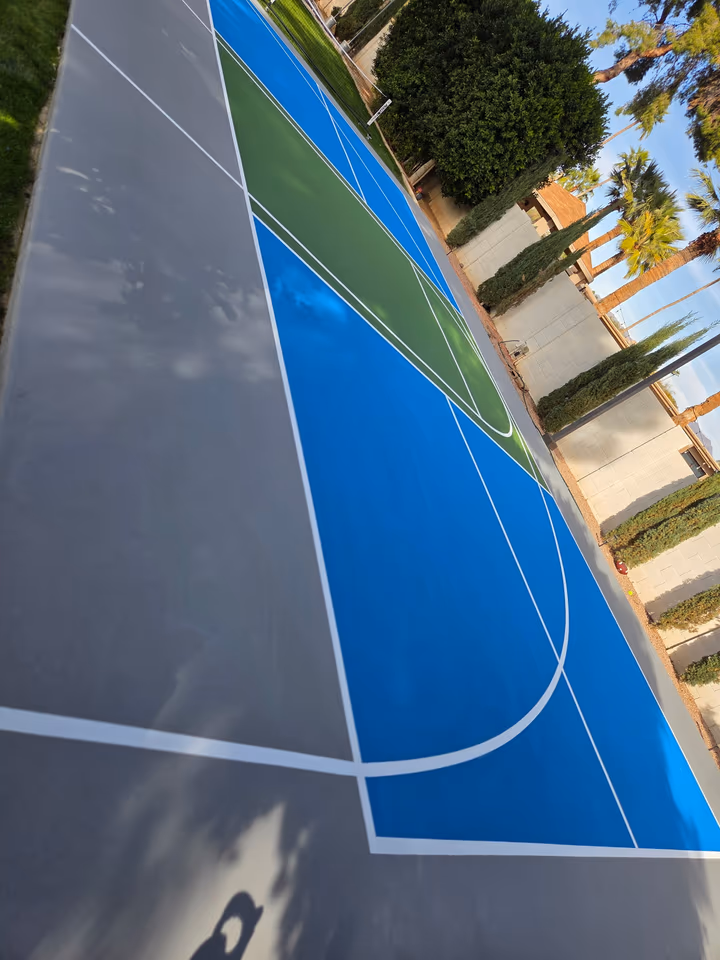 Angled view of a blue basketball court keyway after resurfacing in Arizona