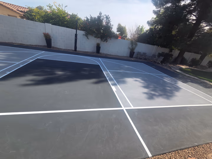 Slate-grey court with fresh white lines after resurfacing in Arizona