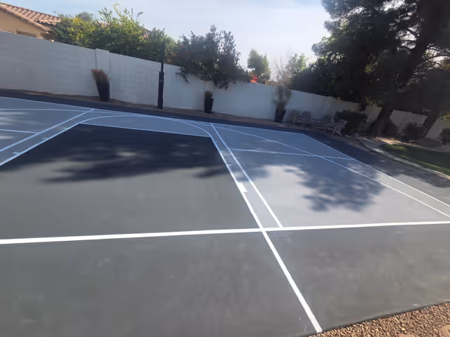 Slate-grey court with fresh white lines after resurfacing in Arizona